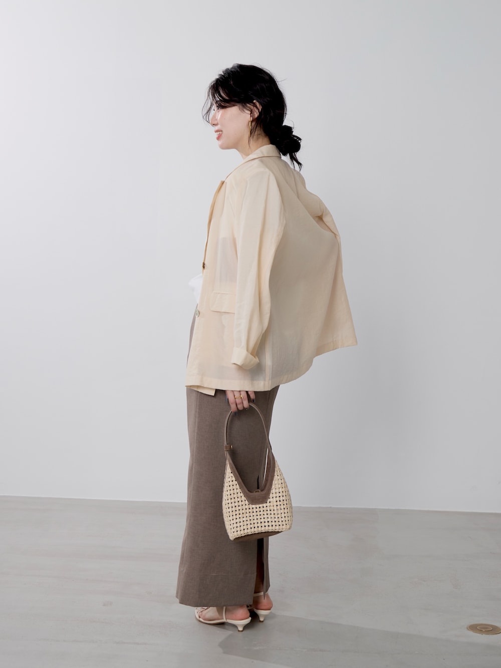 ホワイト系のTシャツ/カットソー、ブラウン系のハンドバッグ、ベージュ系のテーラードジャケットを着用したレディースの春コーディネートの3枚目の写真