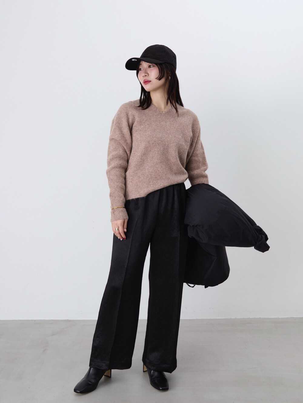 ブラック系のその他パンツ、ブラック系のダウンジャケット/コート、ブラウン系のニット/セーターを着用したレディースの冬コーディネートの2枚目の写真