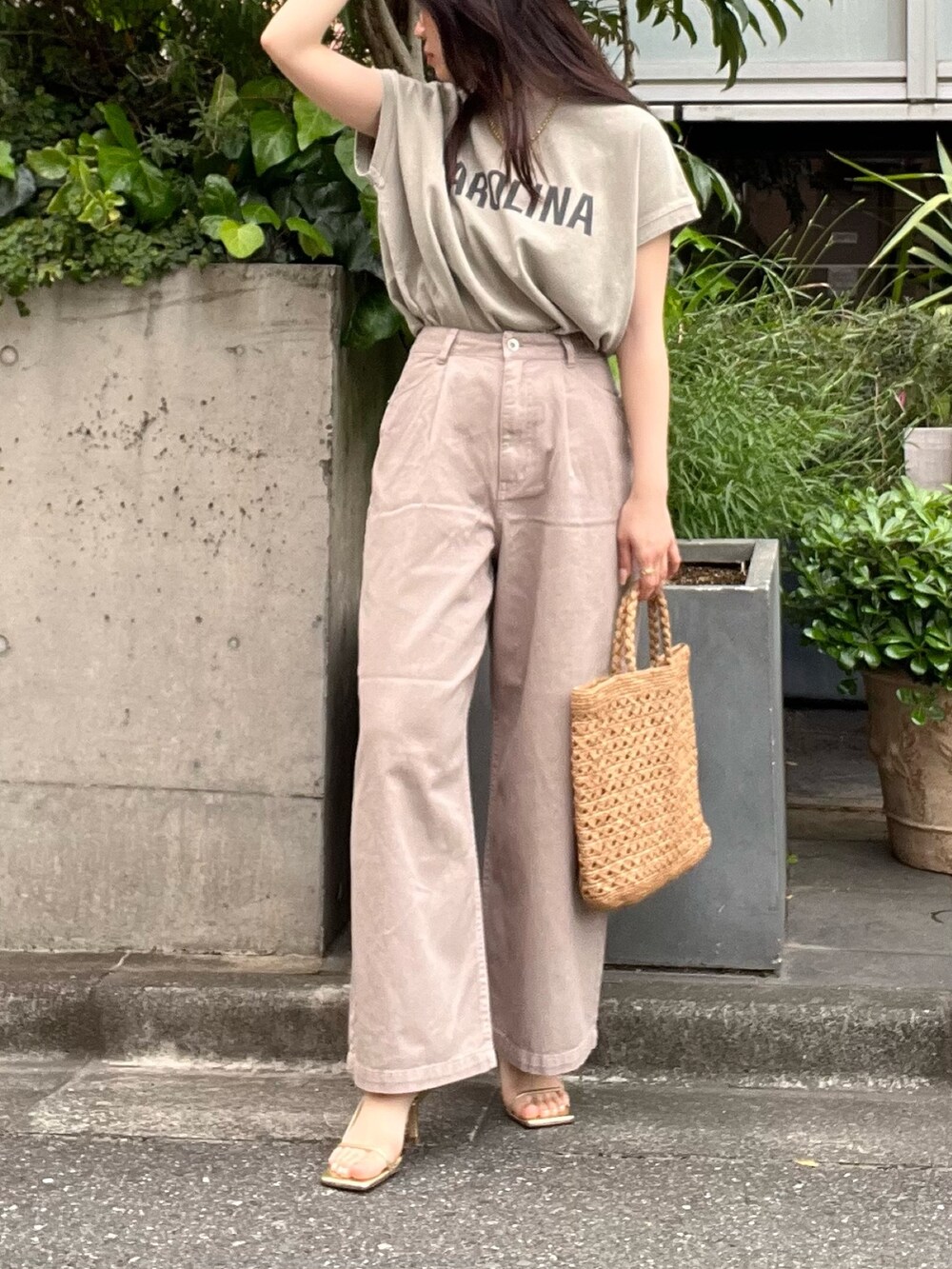 ベージュ系のデニムパンツ、ベージュ系のTシャツ/カットソー、ブラウン系のハンドバッグを着用したレディースの夏コーディネートの3枚目の写真