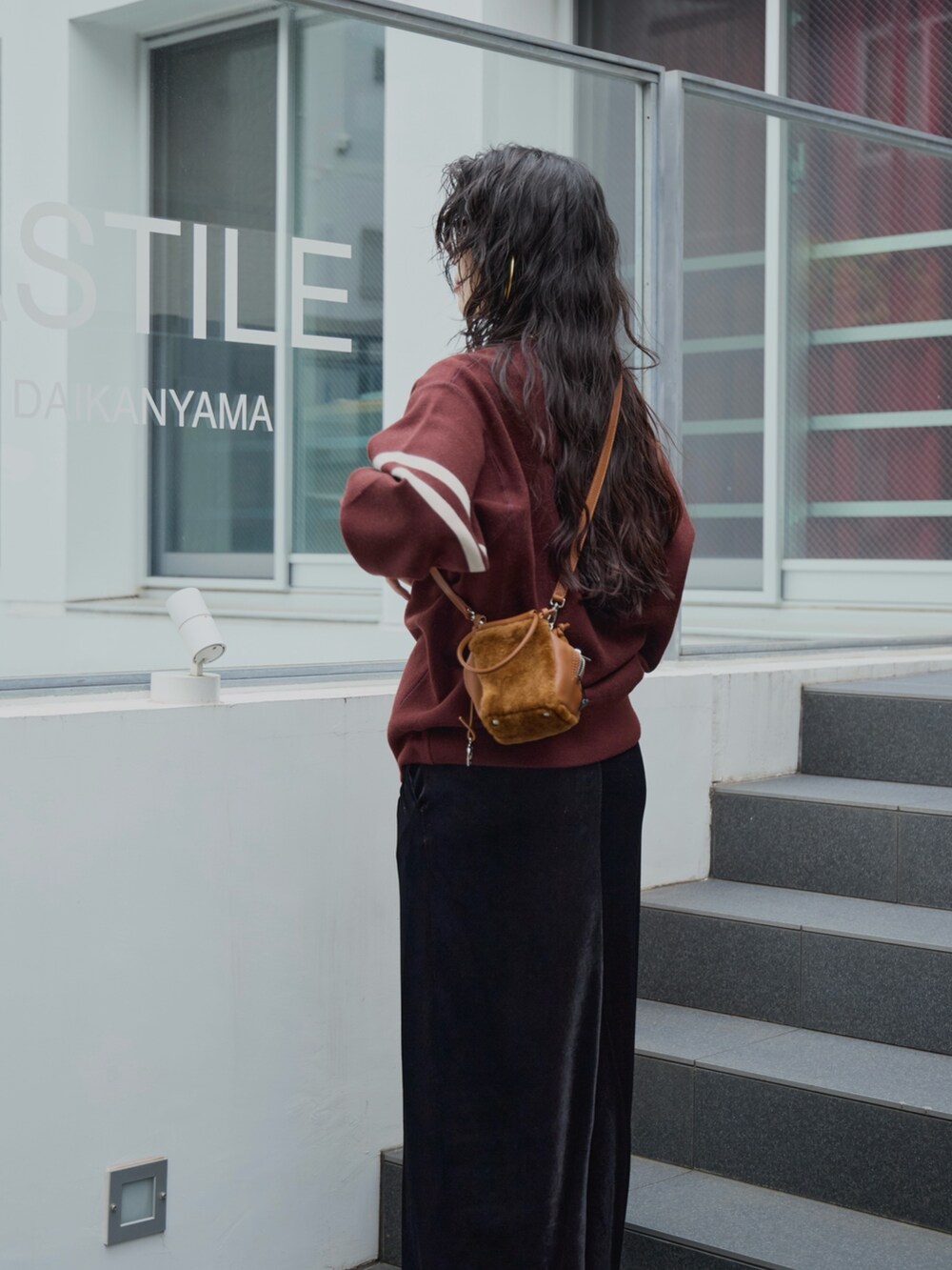 ブラック系のスカート、イエロー系のハンドバッグ、ブラウン系のニット/セーターを着用したレディースの秋コーディネートの4枚目の写真