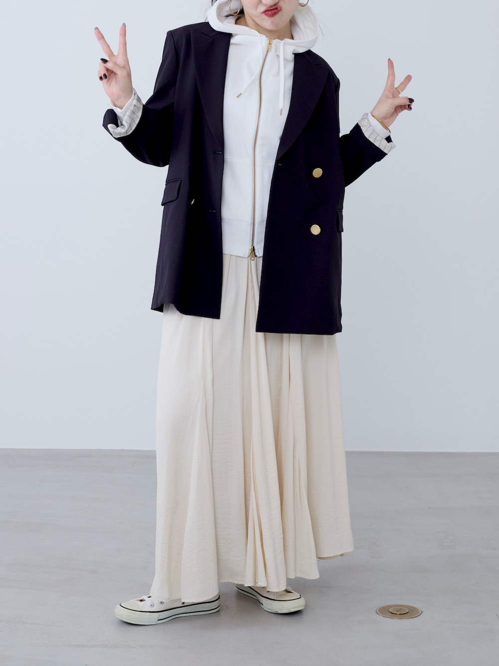 ブルー系のテーラードジャケット、ベージュ系のスカートを着用したレディースの冬コーディネートの2枚目の写真