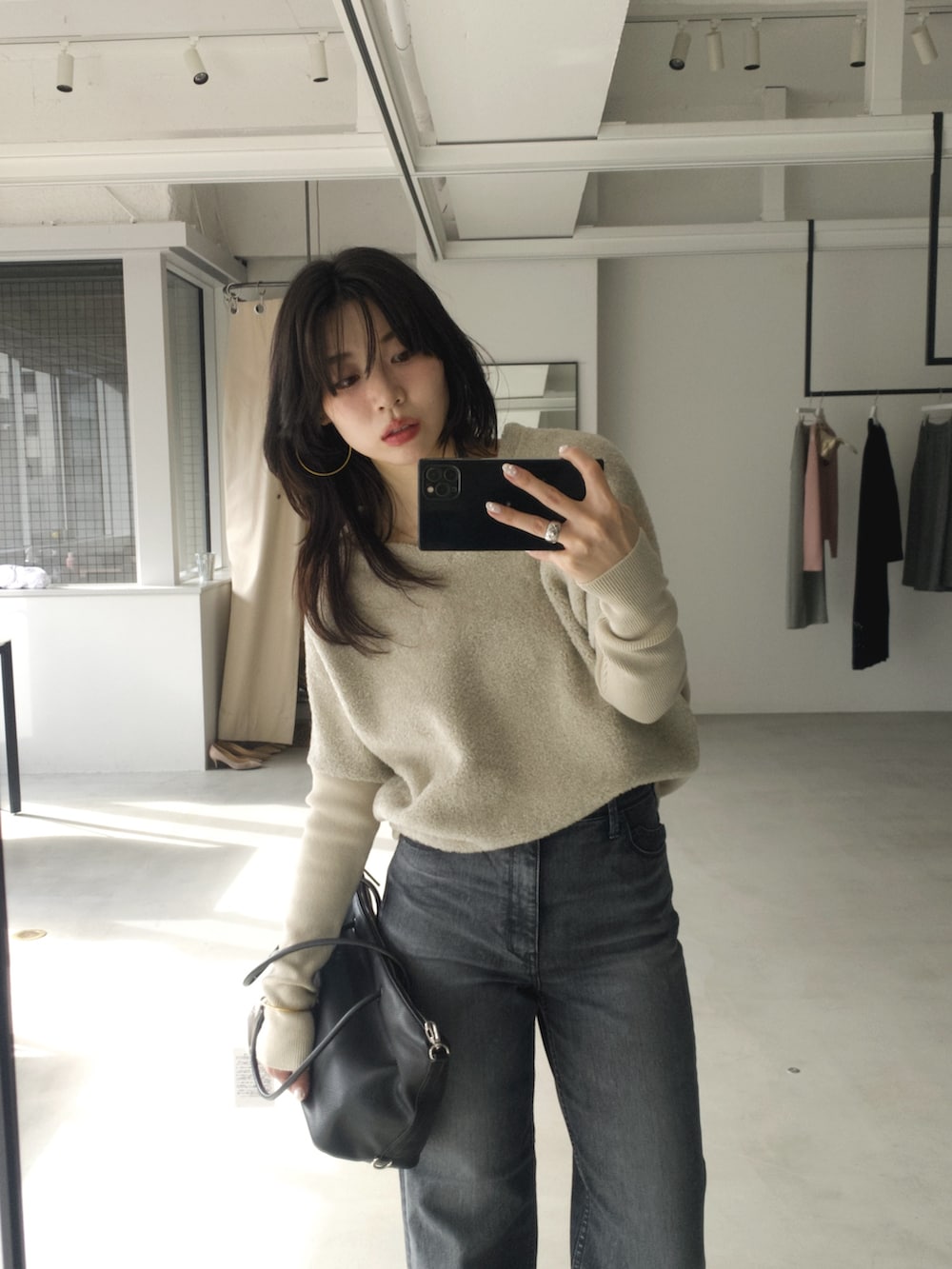 グレー系のニット/セーター、ブラック系のボストンバッグ、グレー系のデニムパンツを着用したレディースの冬コーディネートの3枚目の写真