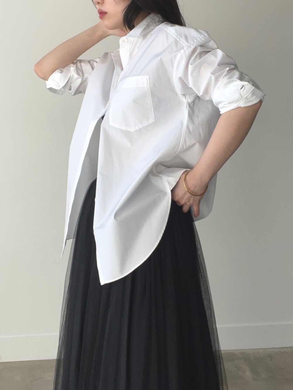 ブラック系のスカート、ホワイト系のシャツ/ブラウスを着用したレディースの春コーディネートの4枚目の写真