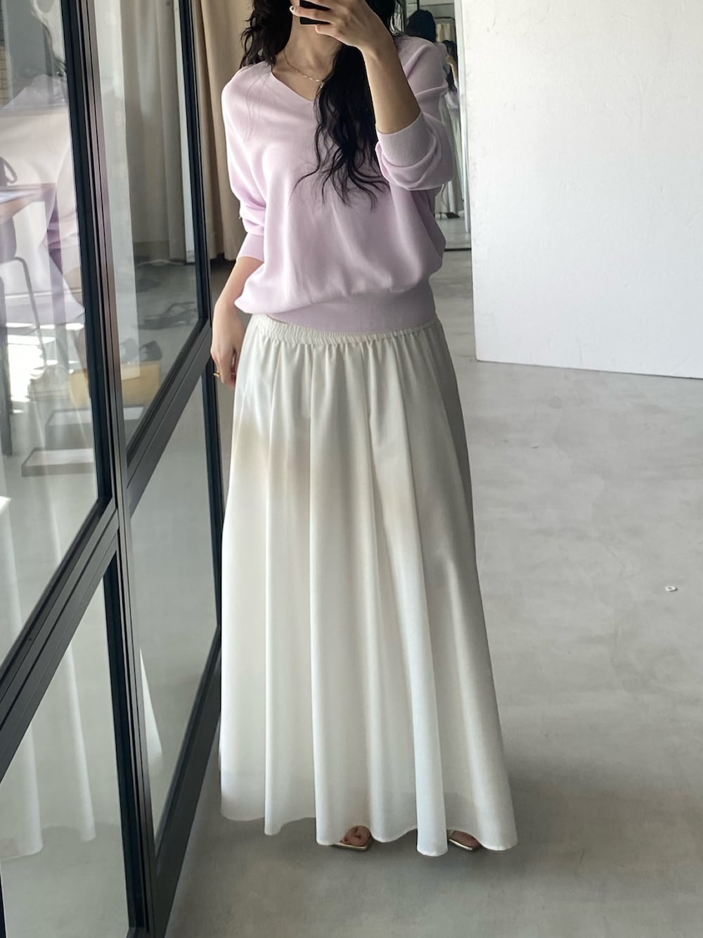 ピンク系のニット/セーター、ホワイト系のスカートを着用したレディースの冬コーディネートの2枚目の写真