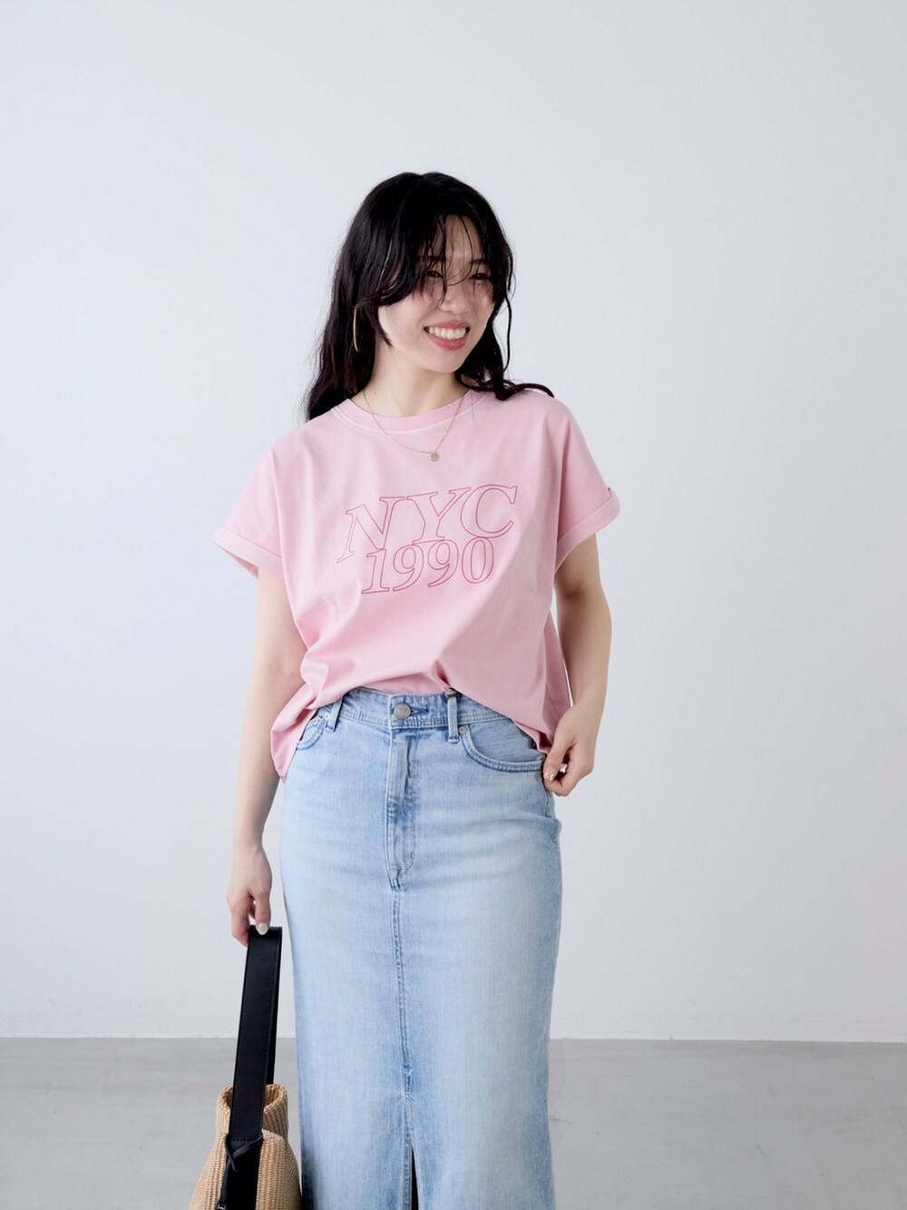 ピンク系のTシャツ/カットソー、ベージュ系のショルダーバッグ、ブルー系のスカートを着用したレディースの夏コーディネートの5枚目の写真