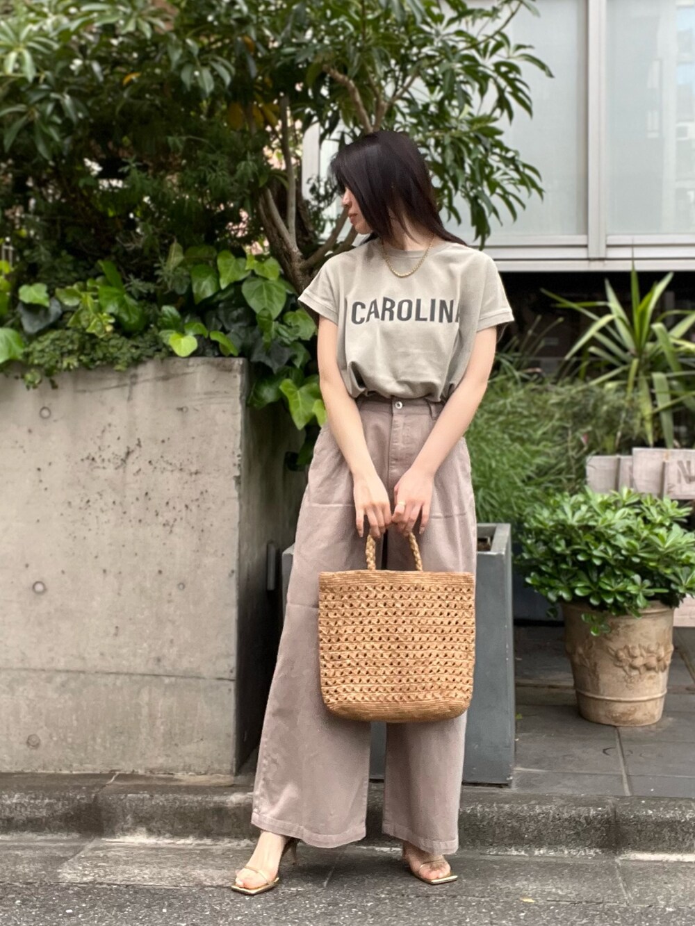 ベージュ系のデニムパンツ、ベージュ系のTシャツ/カットソー、ブラウン系のハンドバッグを着用したレディースの夏コーディネートの2枚目の写真