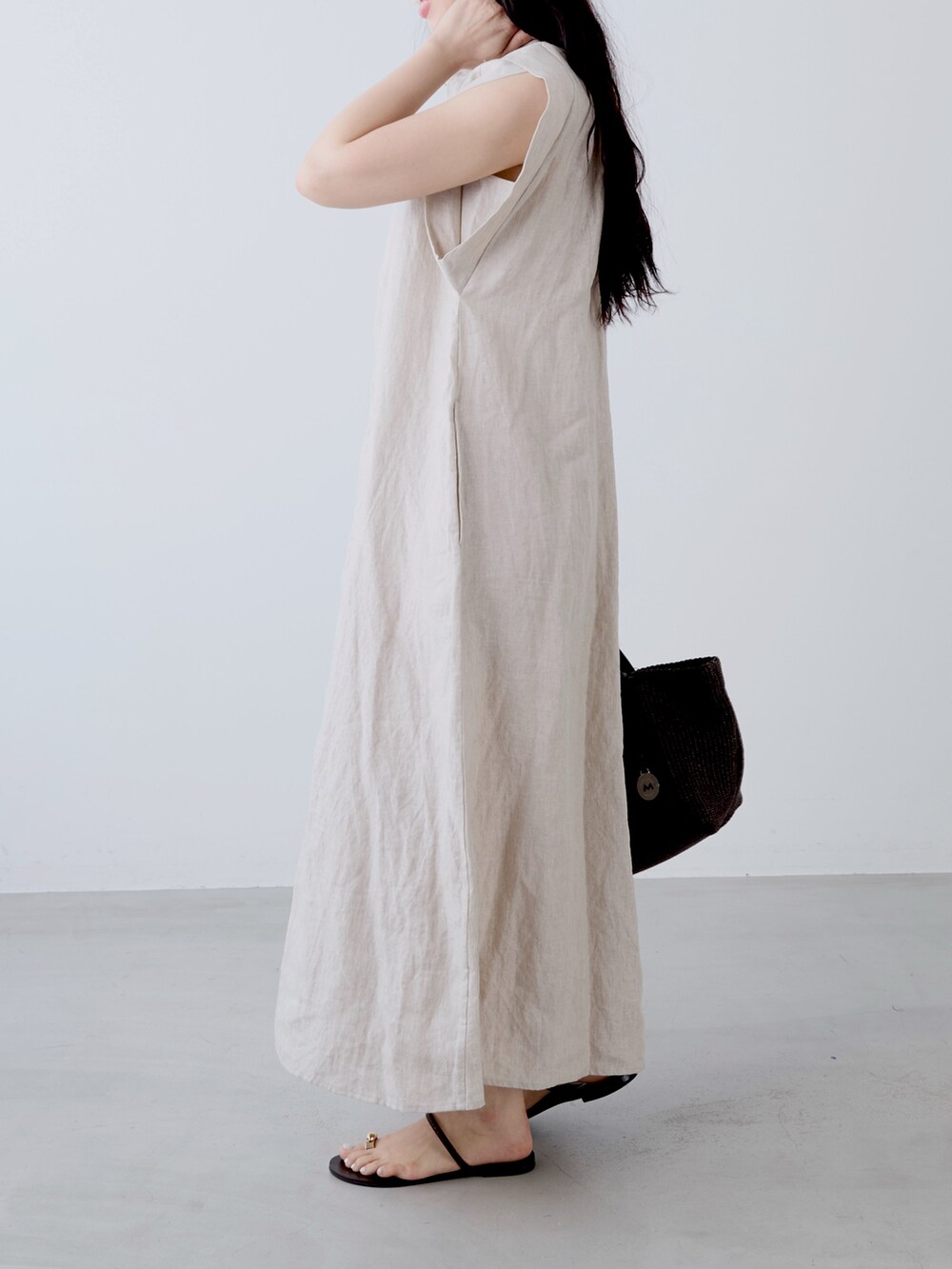 ベージュ系のワンピース、ブラウン系のトートバッグ、ブラウン系のサンダルを着用したレディースの夏コーディネートの3枚目の写真