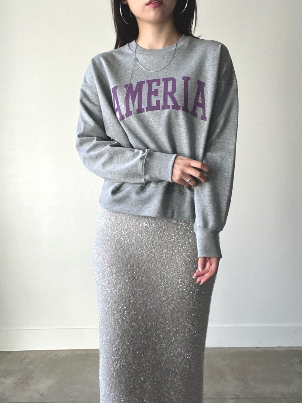 グレー系のスウェット、ベージュ系のスカートを着用したレディースの秋コーディネートの4枚目の写真