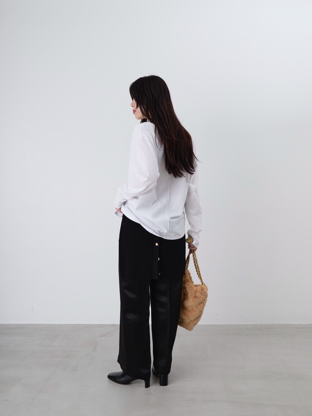 ベージュ系のショルダーバッグ、ホワイト系のTシャツ/カットソー、ブラック系のカーディガン/ボレロを着用したレディースの冬コーディネートの4枚目の写真
