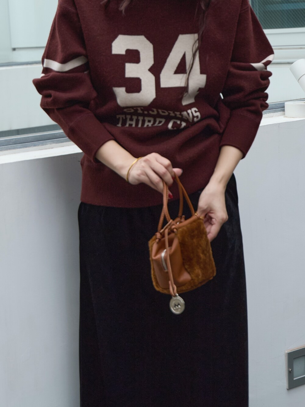 ブラック系のスカート、イエロー系のハンドバッグ、ブラウン系のニット/セーターを着用したレディースの秋コーディネートの6枚目の写真