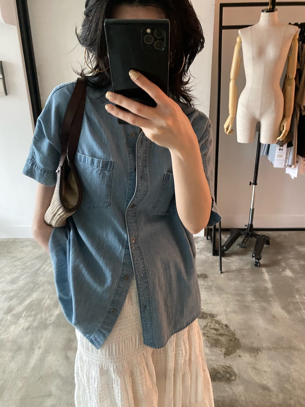 ブルー系のシャツ/ブラウス、ベージュ系のハンドバッグを着用したレディースの春コーディネートの2枚目の写真