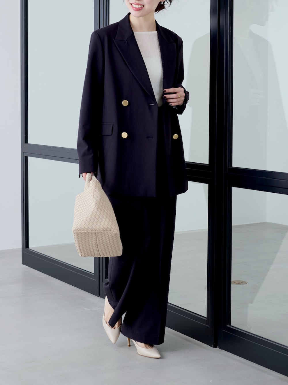 ブルー系のテーラードジャケット、ホワイト系のTシャツ/カットソー、ベージュ系のトートバッグを着用したレディースの冬コーディネートの3枚目の写真