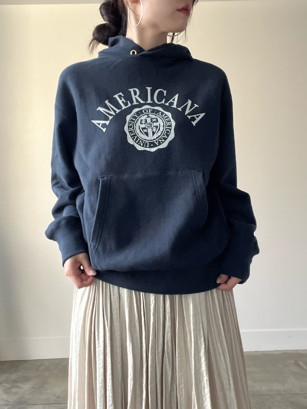 ブラック系のパーカー、ベージュ系のスカートを着用したレディースの秋コーディネートの4枚目の写真