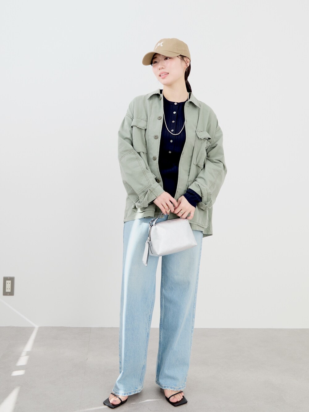 ブルー系のニット/セーター、グリーン系のシャツ/ブラウス、ベージュ系のキャップを着用したレディースの冬コーディネートの2枚目の写真