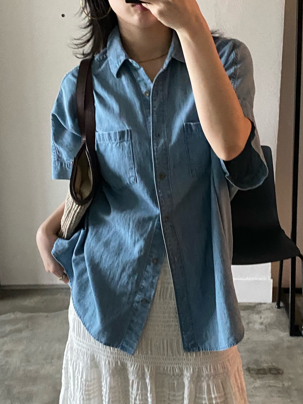 ブルー系のシャツ/ブラウス、ベージュ系のハンドバッグを着用したレディースの春コーディネートの3枚目の写真