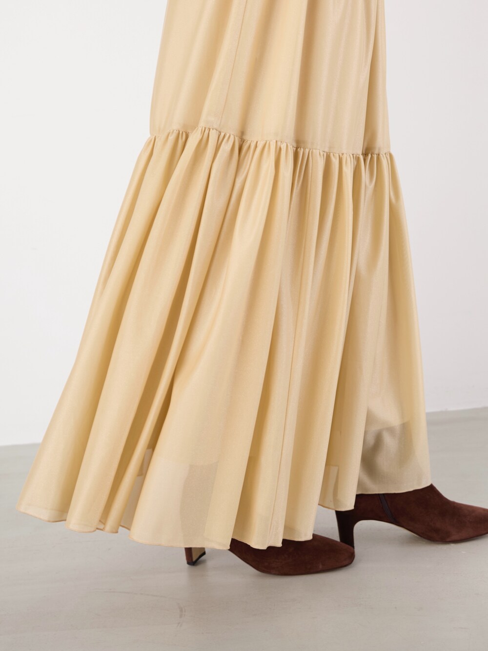 ホワイト系のニット/セーター、ベージュ系のスカート、ブラウン系のハンドバッグを着用したレディースの冬コーディネートの6枚目の写真