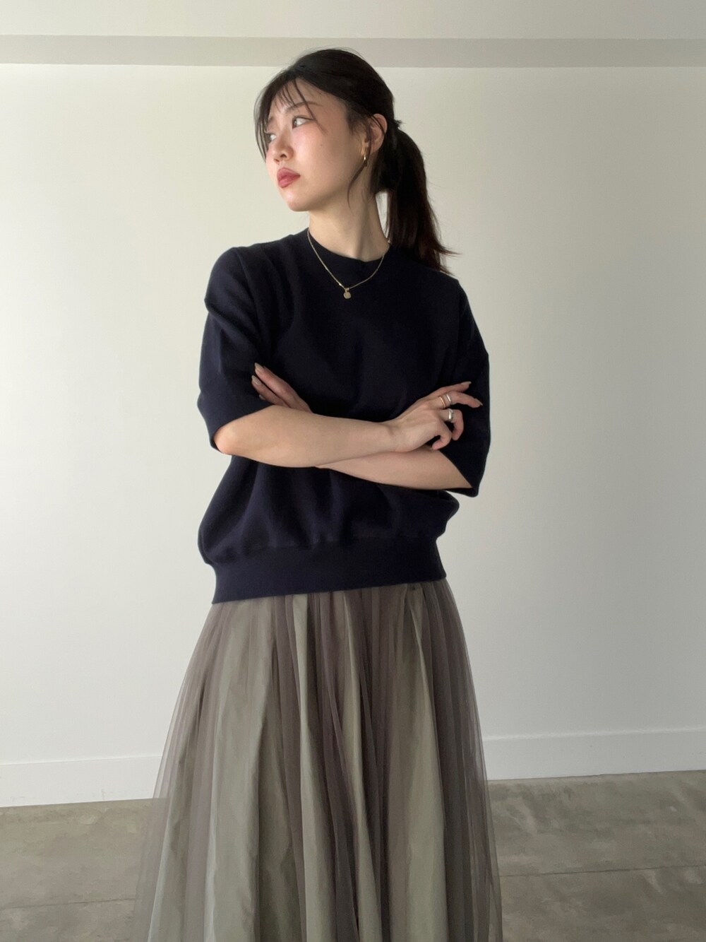 ブルー系のニット/セーター、グリーン系のスカートを着用したレディースの春コーディネートの3枚目の写真