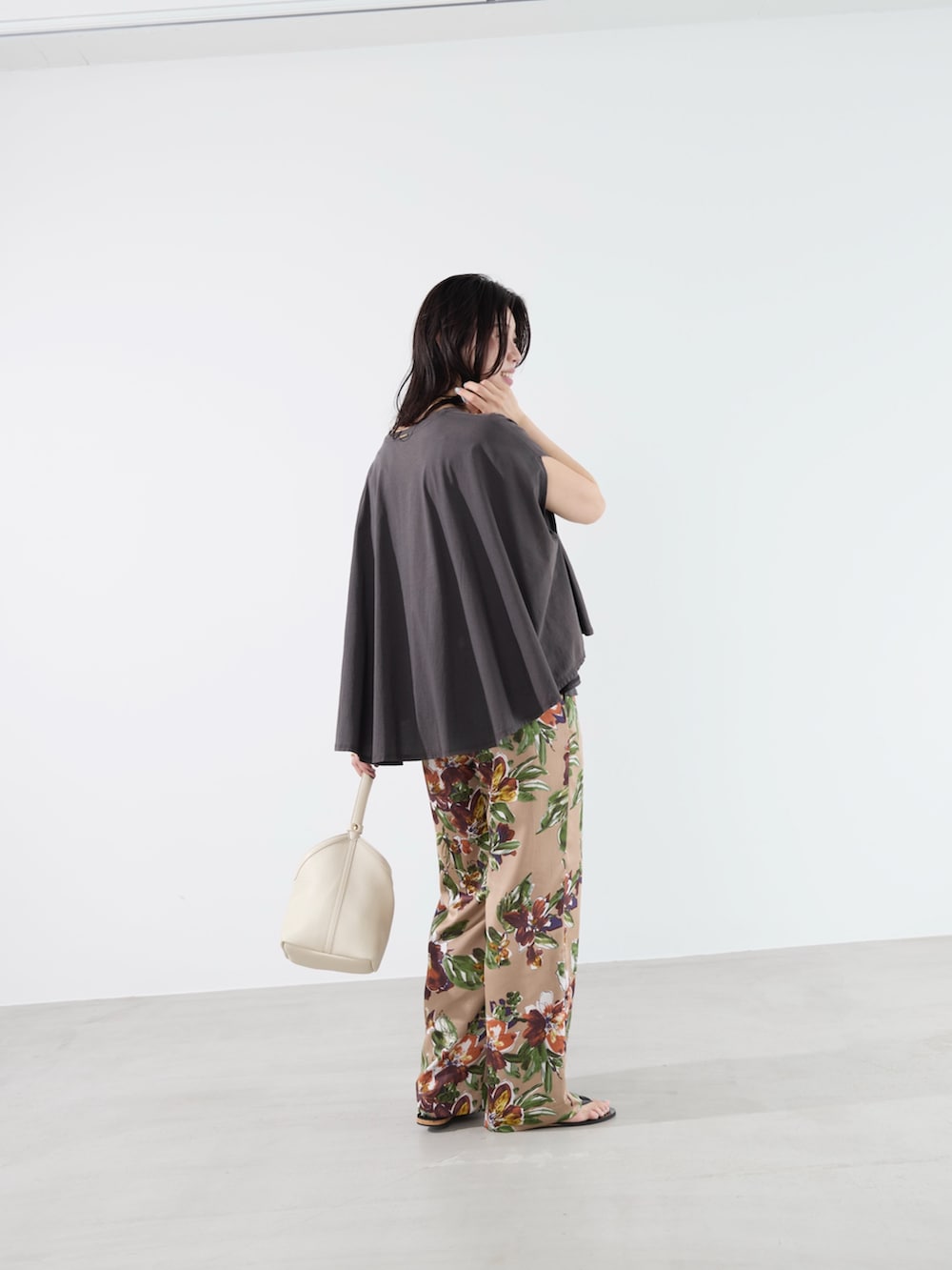 グレー系のTシャツ/カットソー、ベージュ系のその他パンツ、ホワイト系のハンドバッグを着用したレディースの夏コーディネートの4枚目の写真