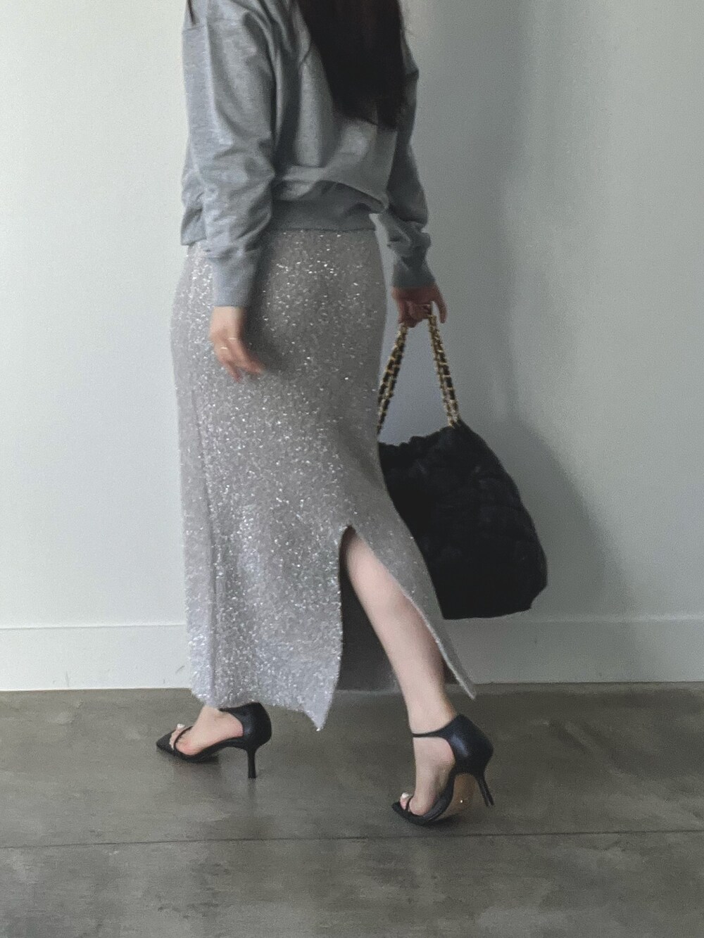 グレー系のスウェット、ベージュ系のスカートを着用したレディースの秋コーディネートの2枚目の写真