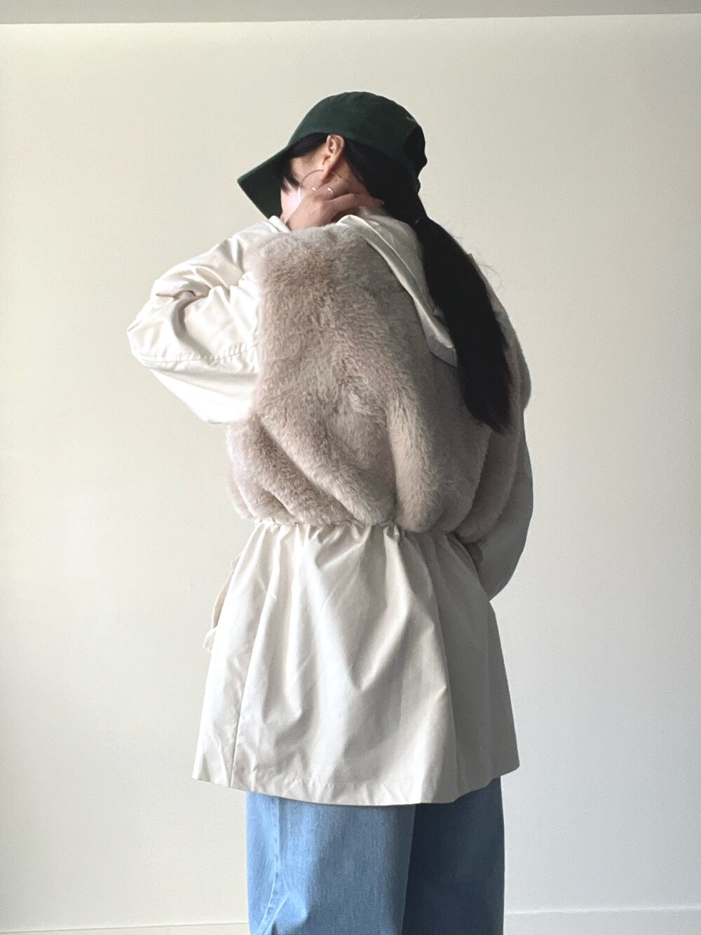 ベージュ系のブルゾン、ブルー系のデニムパンツ、グリーン系のキャップを着用したレディースの秋コーディネートの5枚目の写真