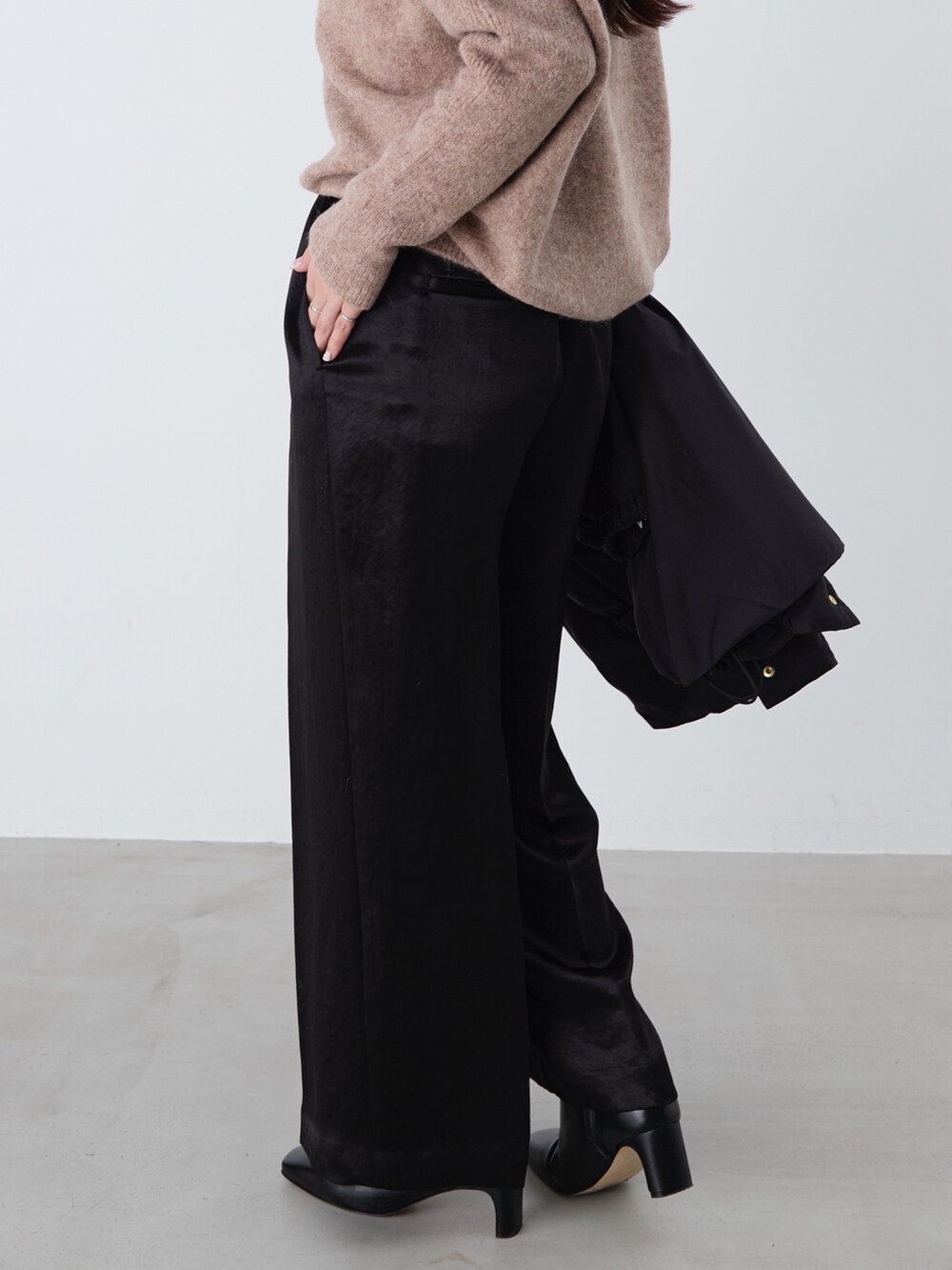 ブラック系のその他パンツ、ブラック系のダウンジャケット/コート、ブラウン系のニット/セーターを着用したレディースの冬コーディネートの8枚目の写真