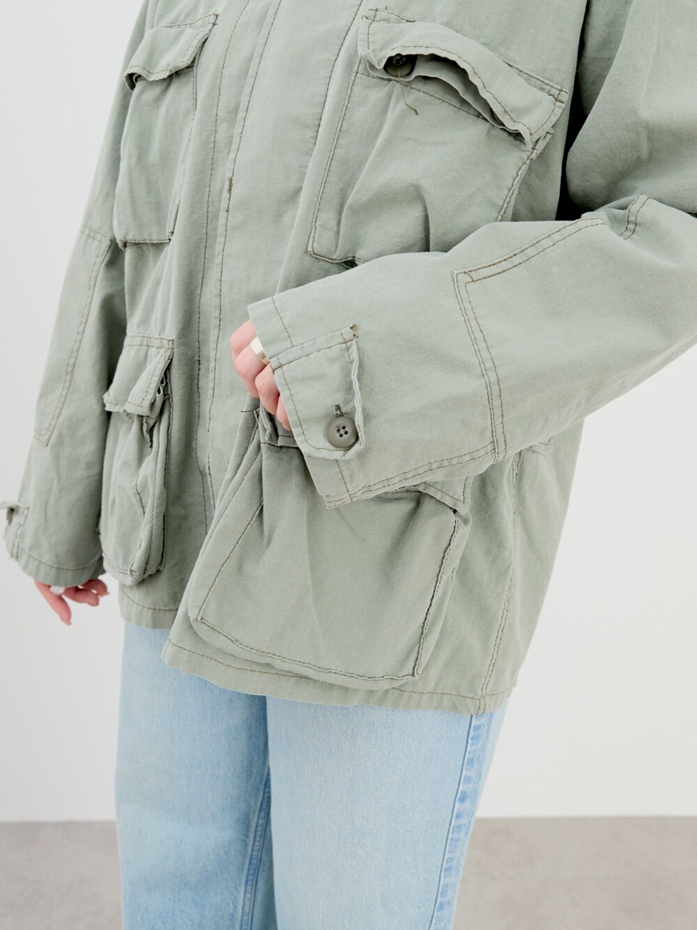 ブルー系のニット/セーター、グリーン系のシャツ/ブラウス、ベージュ系のキャップを着用したレディースの冬コーディネートの8枚目の写真