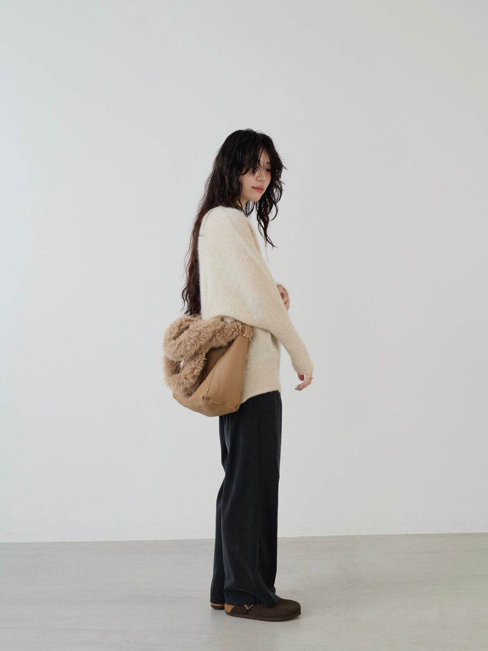 ベージュ系のハンドバッグ、ブラック系のその他パンツ、ホワイト系のニット/セーターを着用したレディースの秋コーディネートの2枚目の写真