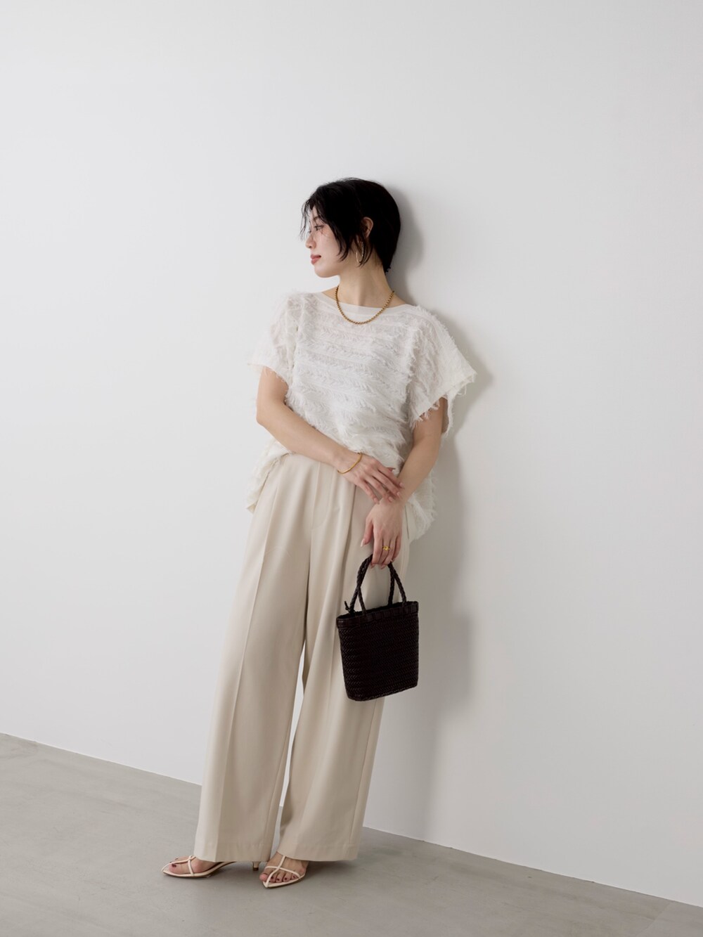 ベージュ系のその他パンツ、ホワイト系のニット/セーターを着用したレディースの春コーディネートの6枚目の写真