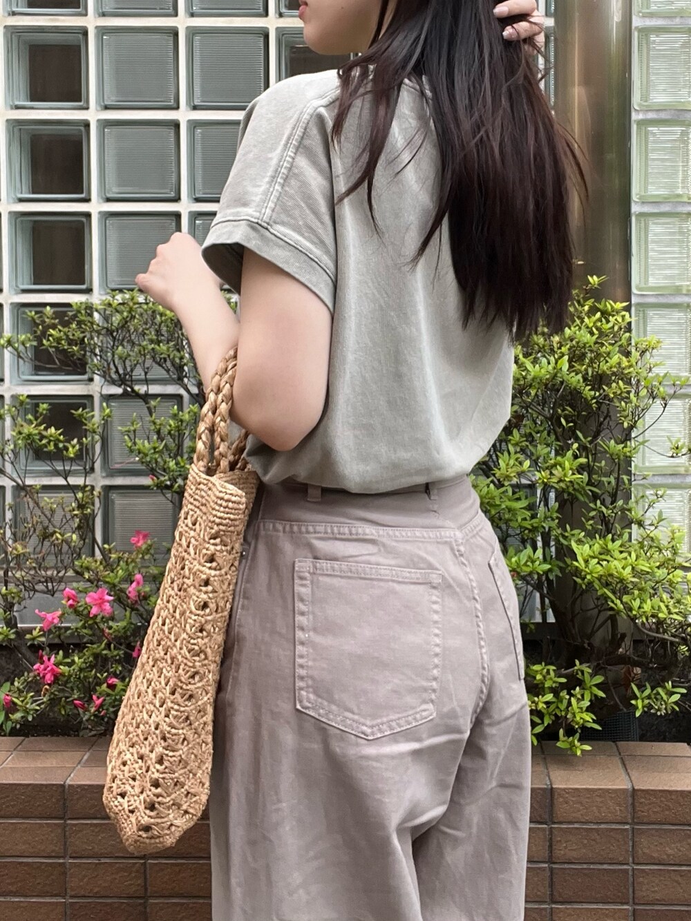 ベージュ系のデニムパンツ、ベージュ系のTシャツ/カットソー、ブラウン系のハンドバッグを着用したレディースの夏コーディネートの6枚目の写真