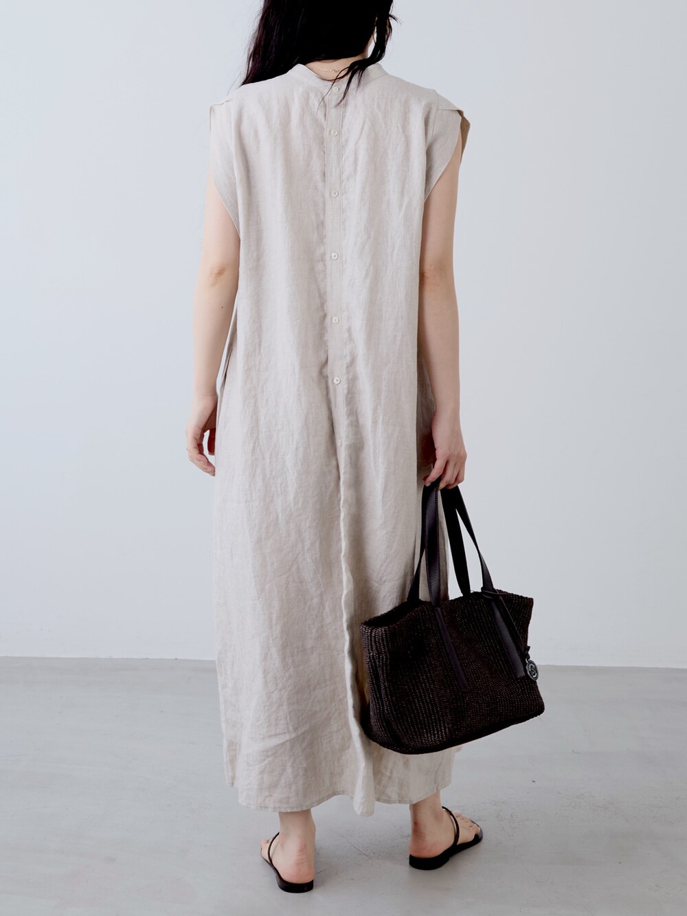 ベージュ系のワンピース、ブラウン系のトートバッグ、ブラウン系のサンダルを着用したレディースの夏コーディネートの5枚目の写真