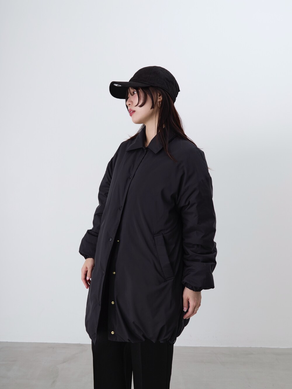 ブラック系のその他パンツ、ブラック系のダウンジャケット/コート、ブラウン系のニット/セーターを着用したレディースの冬コーディネートの9枚目の写真