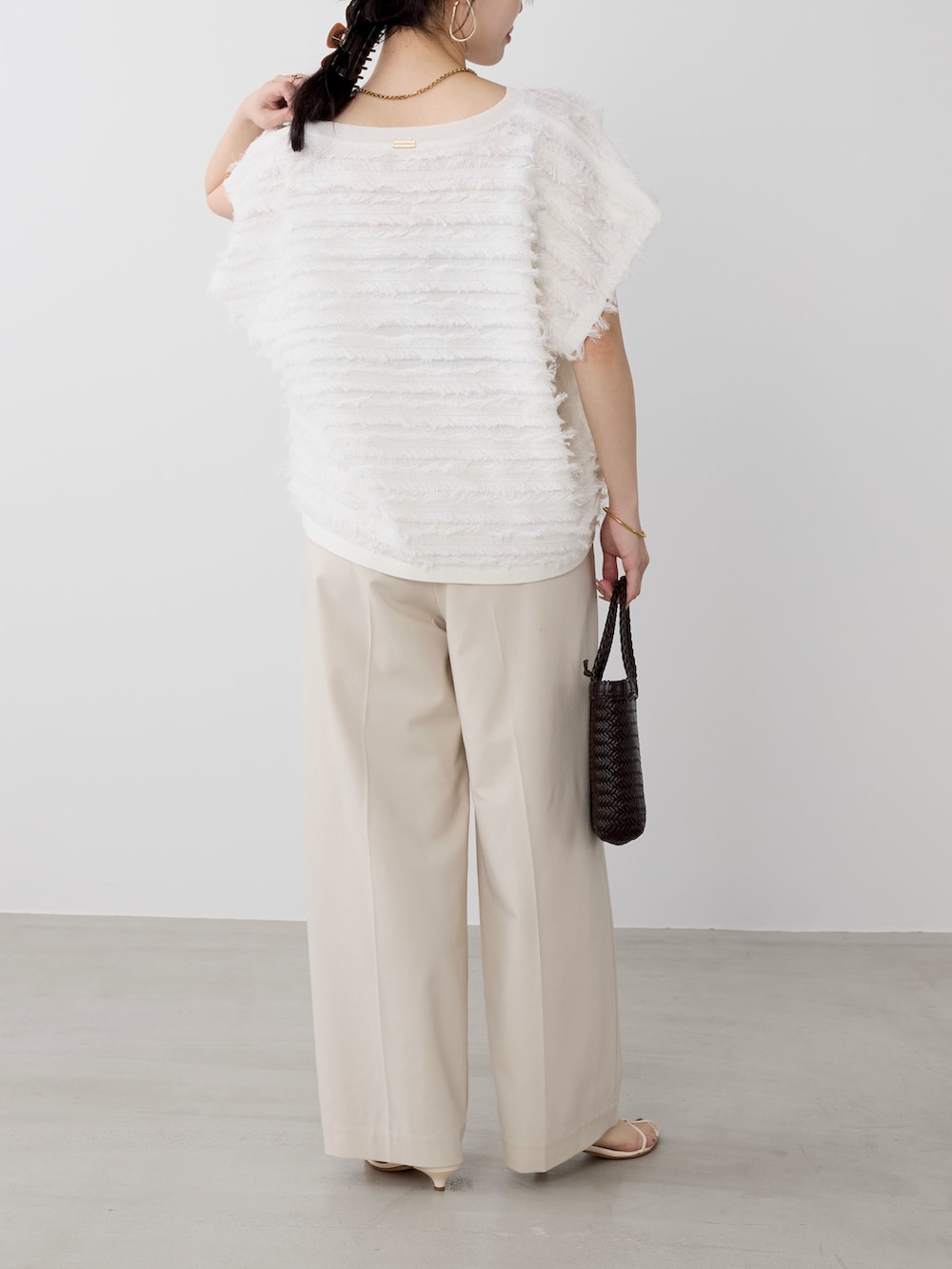 ベージュ系のその他パンツ、ホワイト系のニット/セーターを着用したレディースの春コーディネートの4枚目の写真