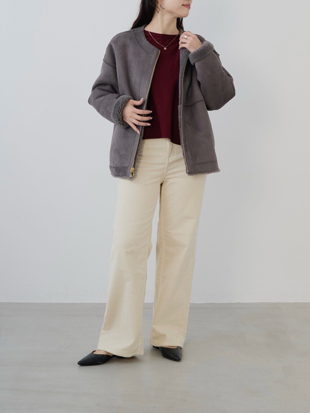 ブラック系のボストンバッグ、レッド系のニット/セーター、グレー系のノーカラーコートを着用したレディースの秋コーディネートの2枚目の写真