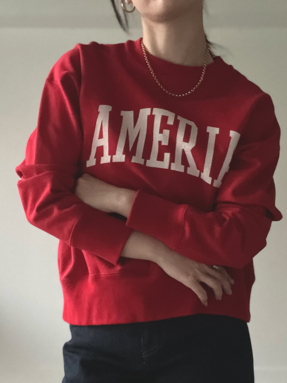 レッド系のスウェットを着用したレディースの秋コーディネートの2枚目の写真