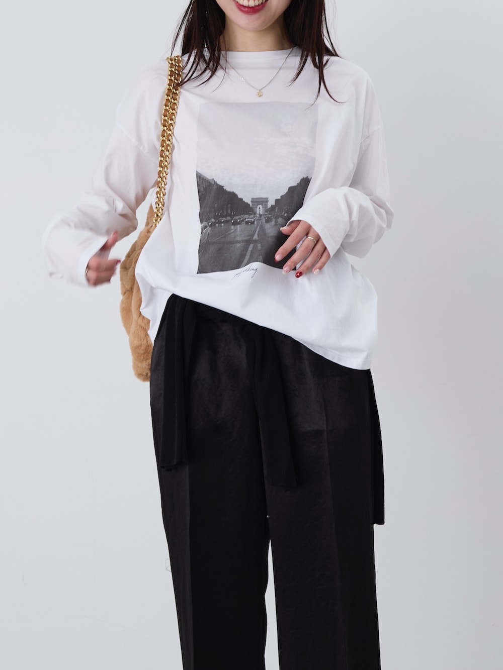 ベージュ系のショルダーバッグ、ホワイト系のTシャツ/カットソー、ブラック系のカーディガン/ボレロを着用したレディースの冬コーディネートの2枚目の写真