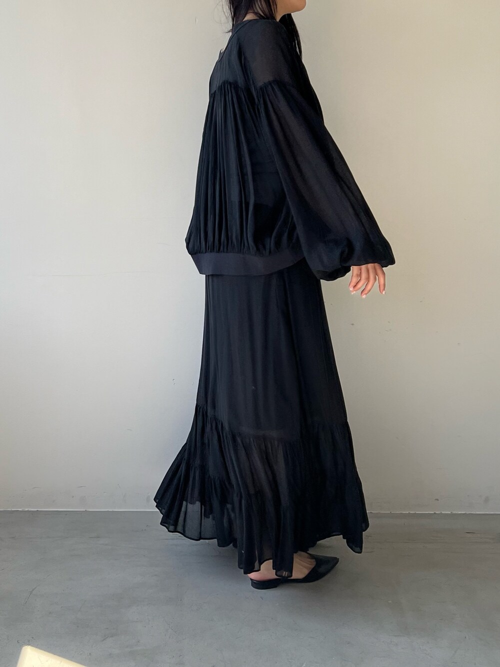 ブラック系のスカート、シルバー系のタンクトップ、ブラック系のカーディガン/ボレロを着用したレディースの春コーディネートの4枚目の写真