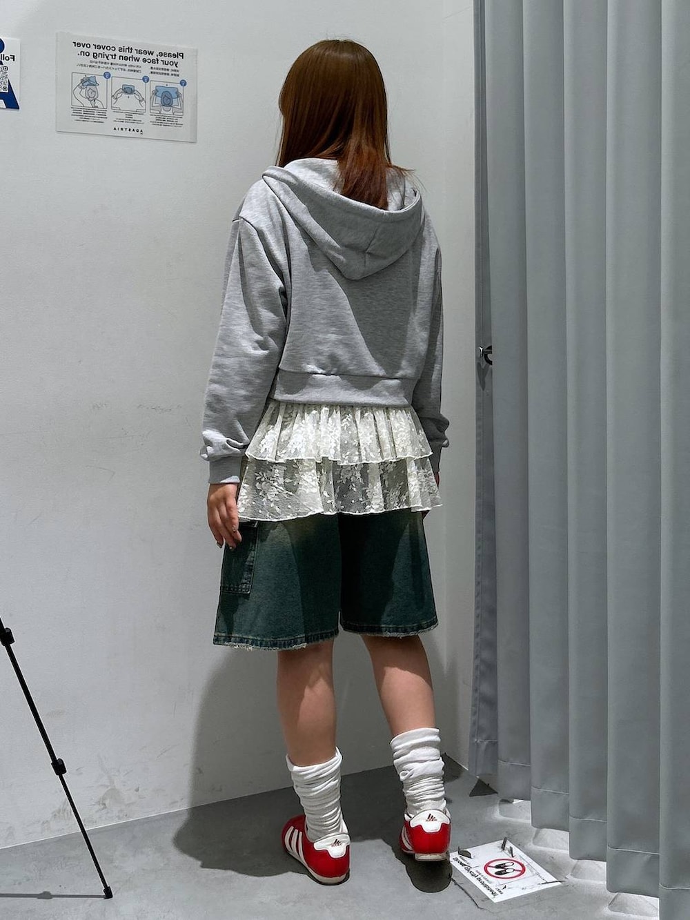 グレー系のパーカー、ホワイト系のワンピース、ブルー系のデニムパンツを着用したレディースの春コーディネートの4枚目の写真