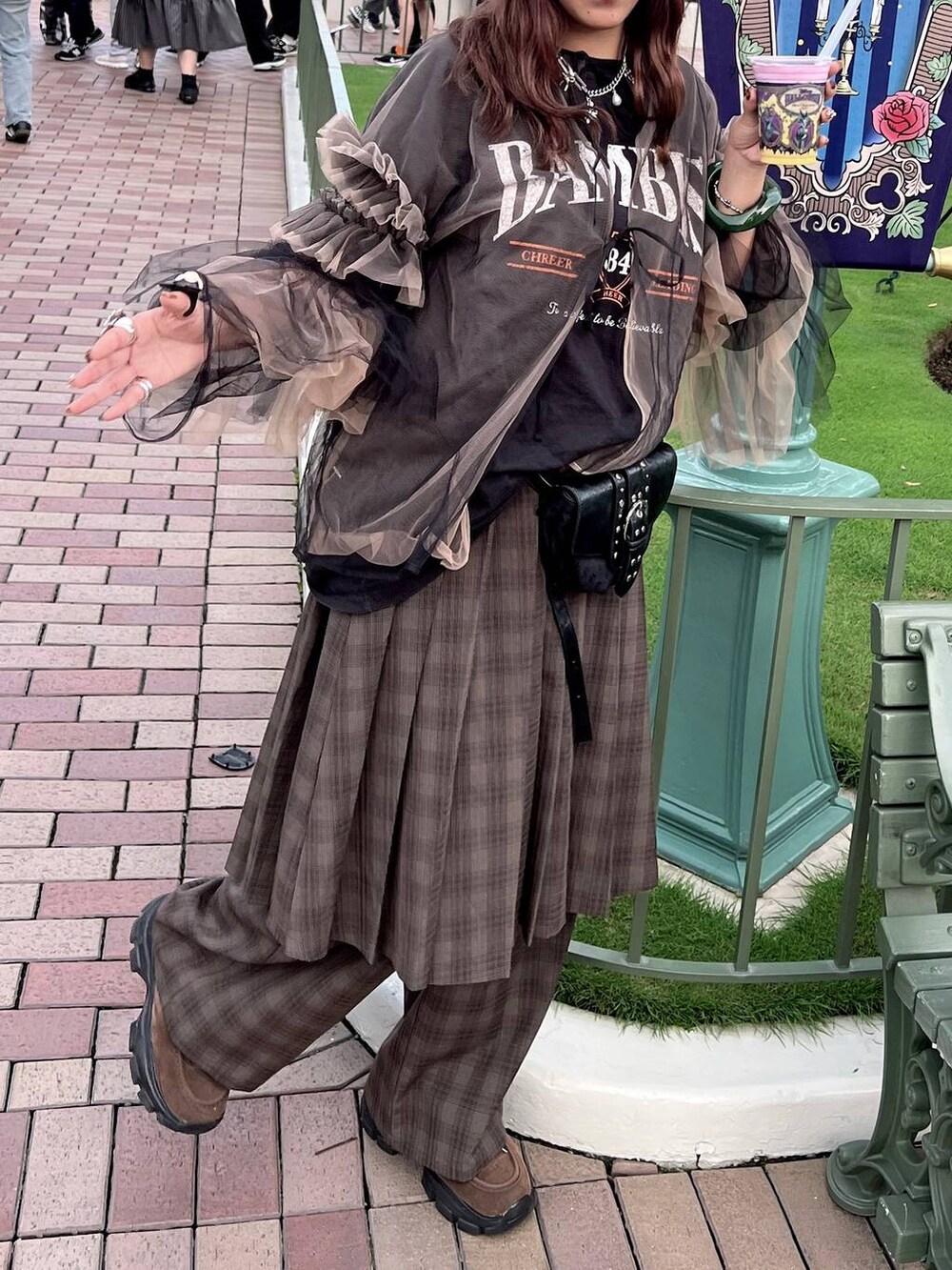 ブラウン系のモカシン/デッキシューズ、ブラック系のショルダーバッグ、グリーン系のスラックスを着用したレディースの秋コーディネートの2枚目の写真