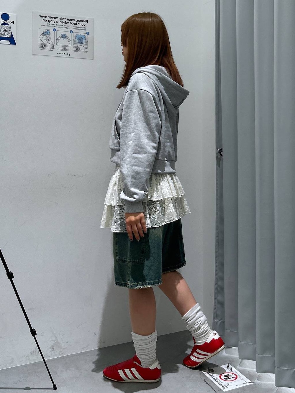 グレー系のパーカー、ホワイト系のワンピース、ブルー系のデニムパンツを着用したレディースの春コーディネートの5枚目の写真
