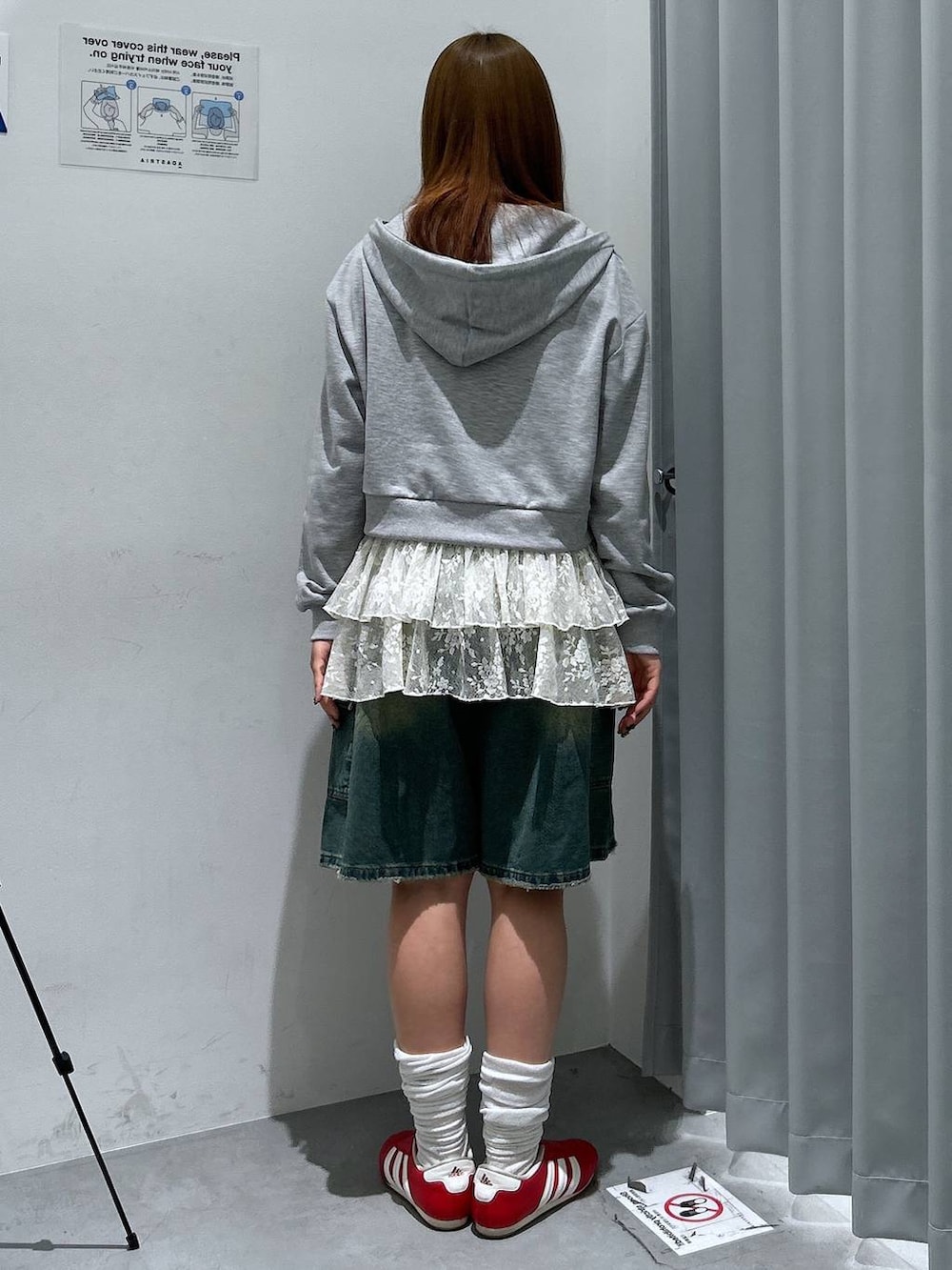 グレー系のパーカー、ホワイト系のワンピース、ブルー系のデニムパンツを着用したレディースの春コーディネートの3枚目の写真
