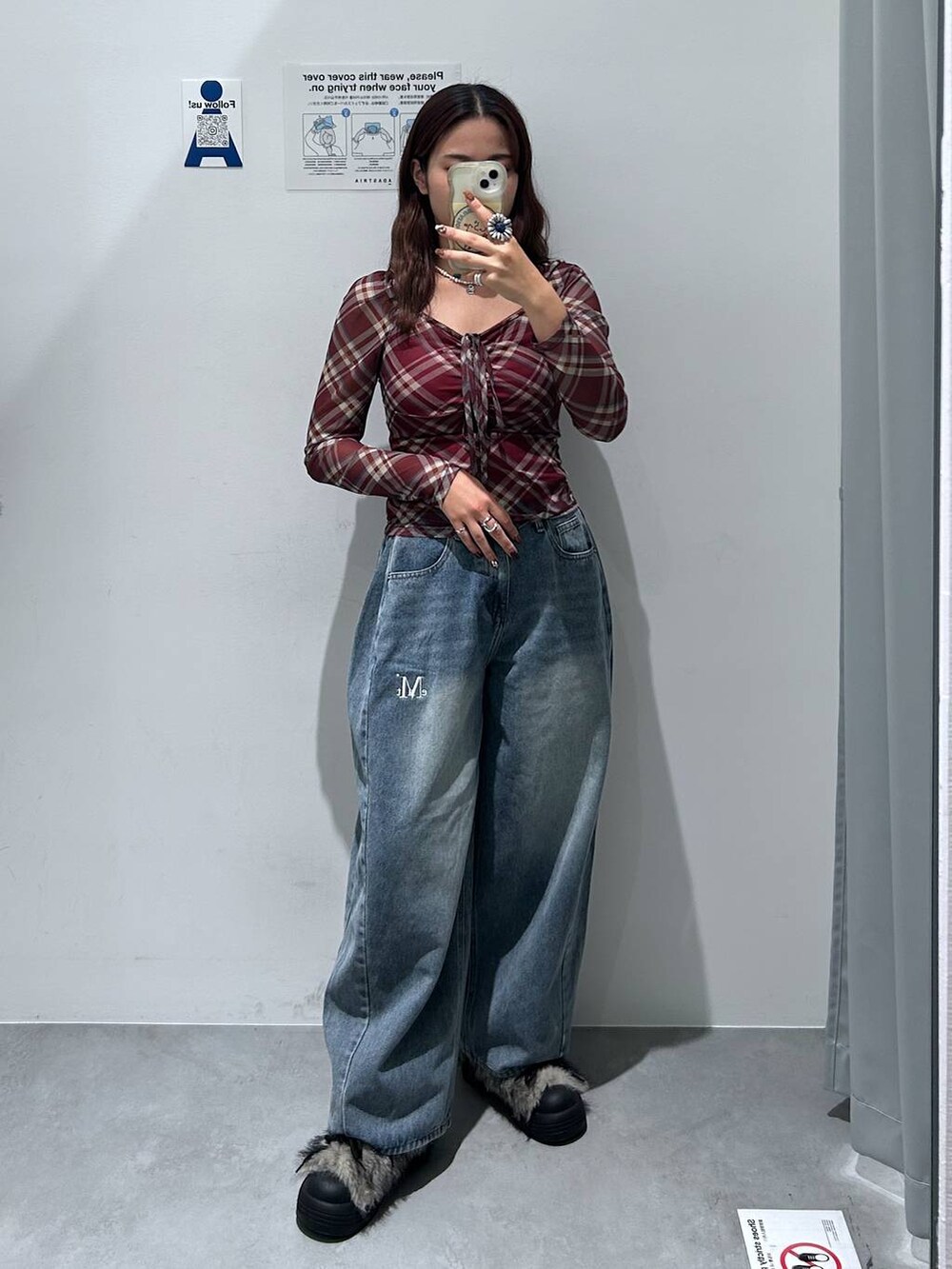 ブルー系のデニムパンツ、レッド系のTシャツ/カットソー、グレー系のブーツを着用したレディースの秋コーディネートの3枚目の写真