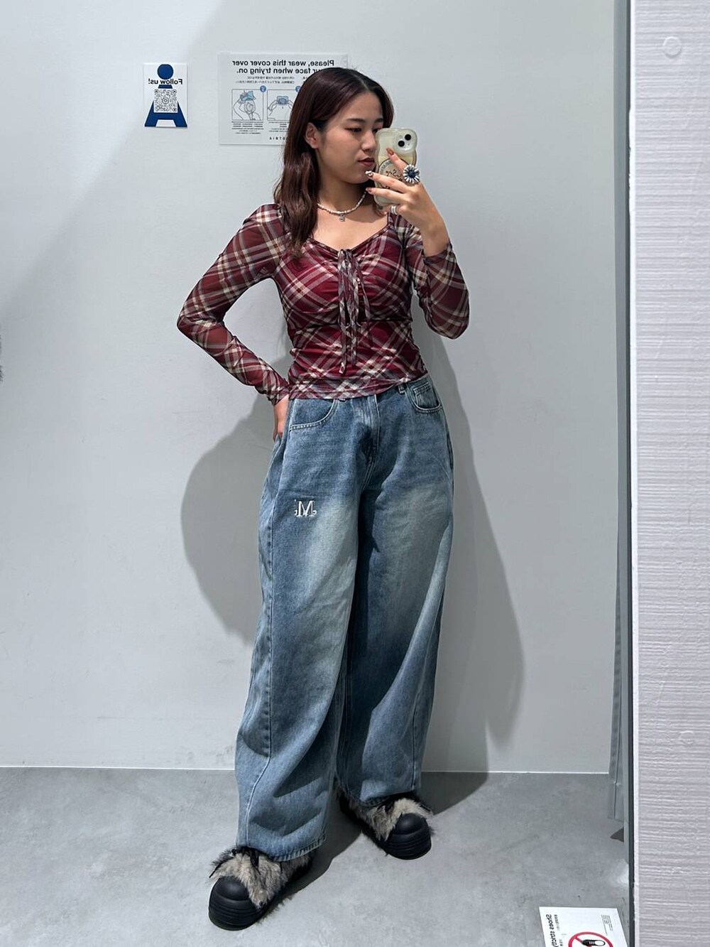 ブルー系のデニムパンツ、レッド系のTシャツ/カットソー、グレー系のブーツを着用したレディースの秋コーディネートの2枚目の写真