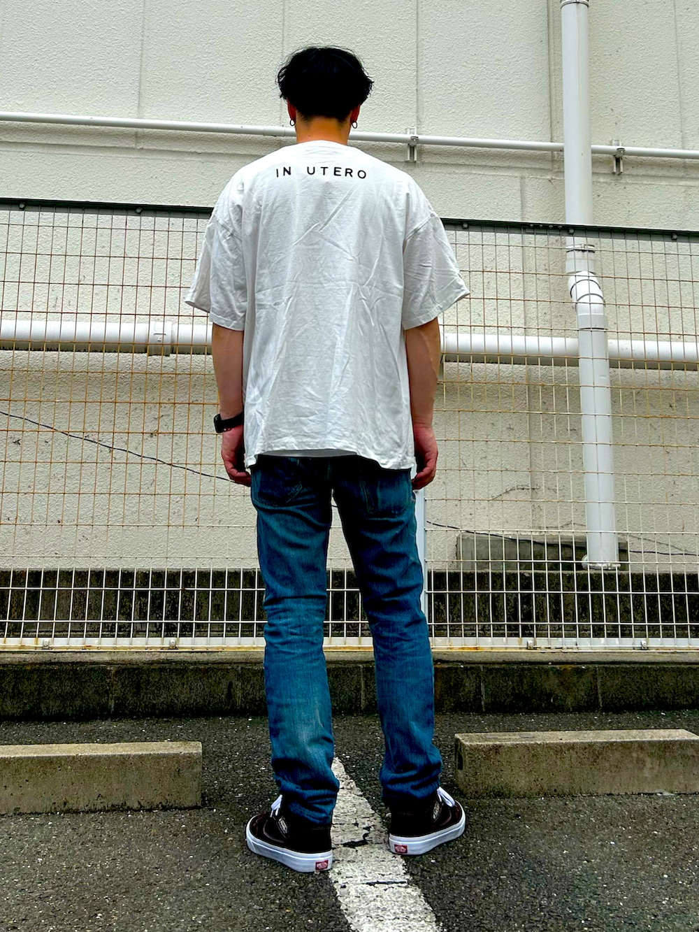 ホワイト系のTシャツ/カットソー、ブルー系のデニムパンツ、ブラウン系のスニーカーを着用したメンズの夏コーディネートの3枚目の写真