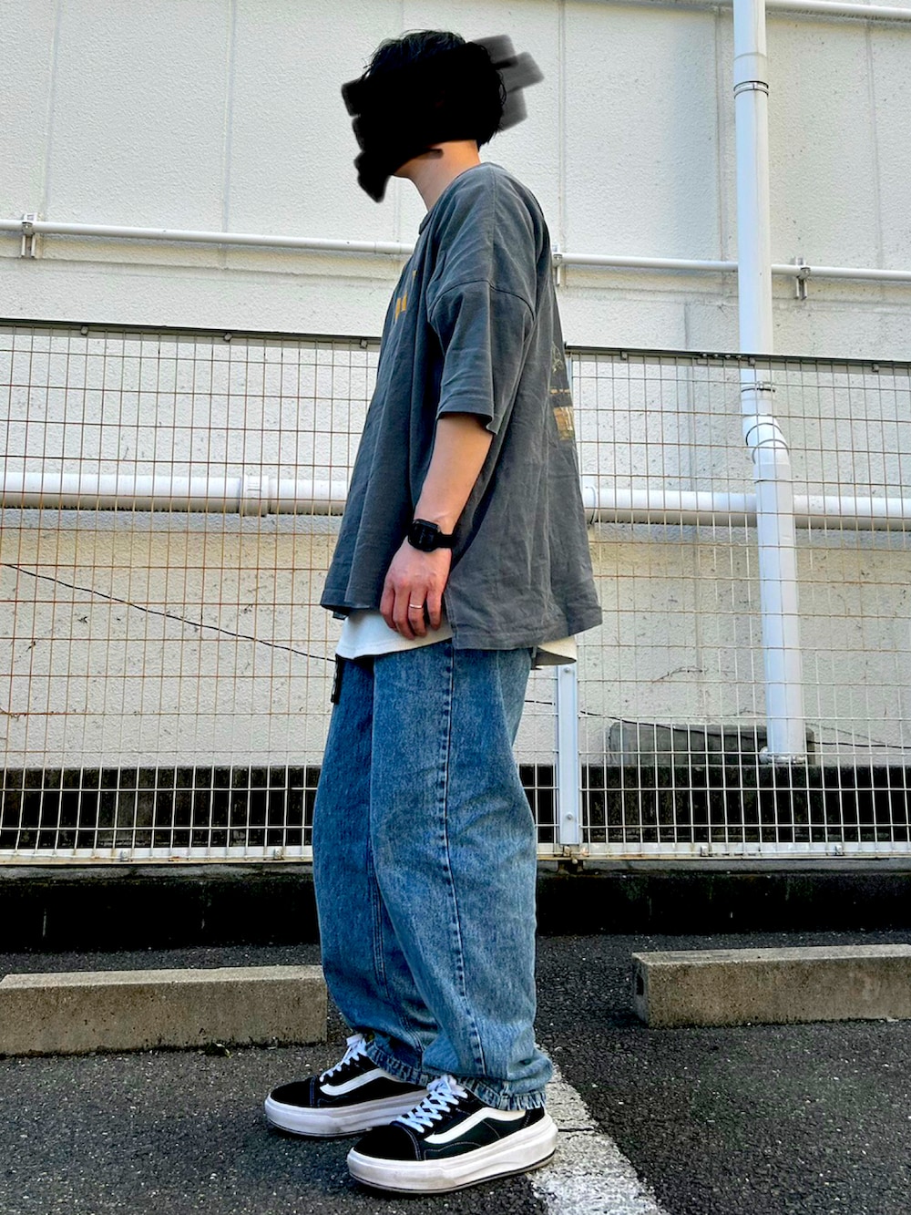 グレー系のTシャツ/カットソー、ブルー系のデニムパンツ、ブラック系のスニーカーを着用したメンズの夏コーディネートの2枚目の写真