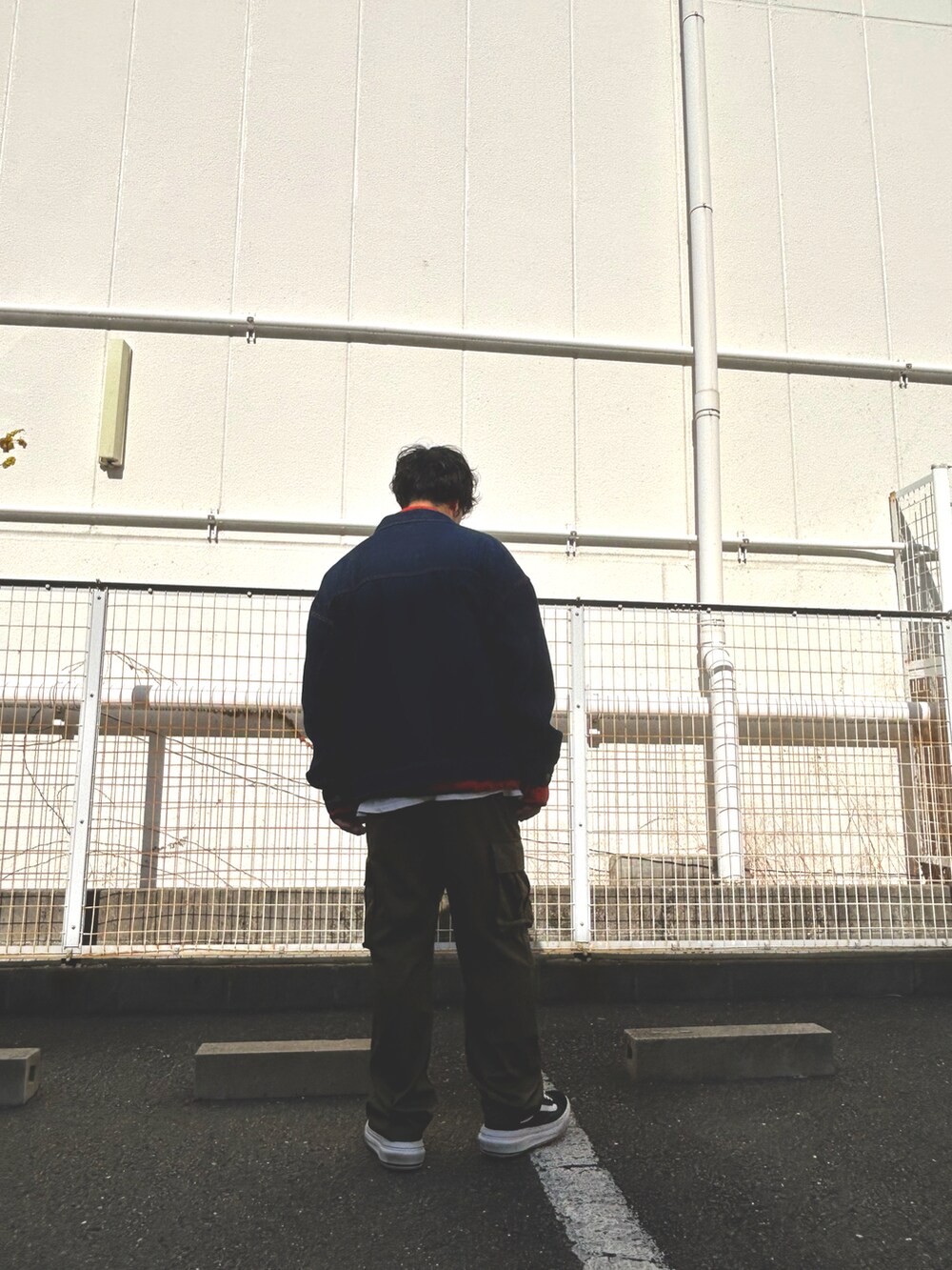 オレンジ系のスウェット、ブラック系のデニムジャケット、グリーン系のカーゴパンツを着用したメンズの冬コーディネートの5枚目の写真