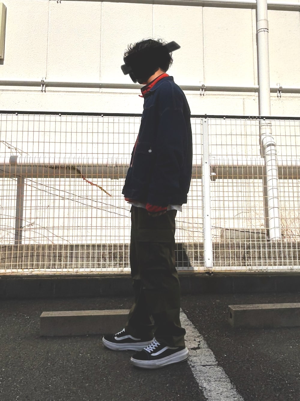 オレンジ系のスウェット、ブラック系のデニムジャケット、グリーン系のカーゴパンツを着用したメンズの冬コーディネートの2枚目の写真