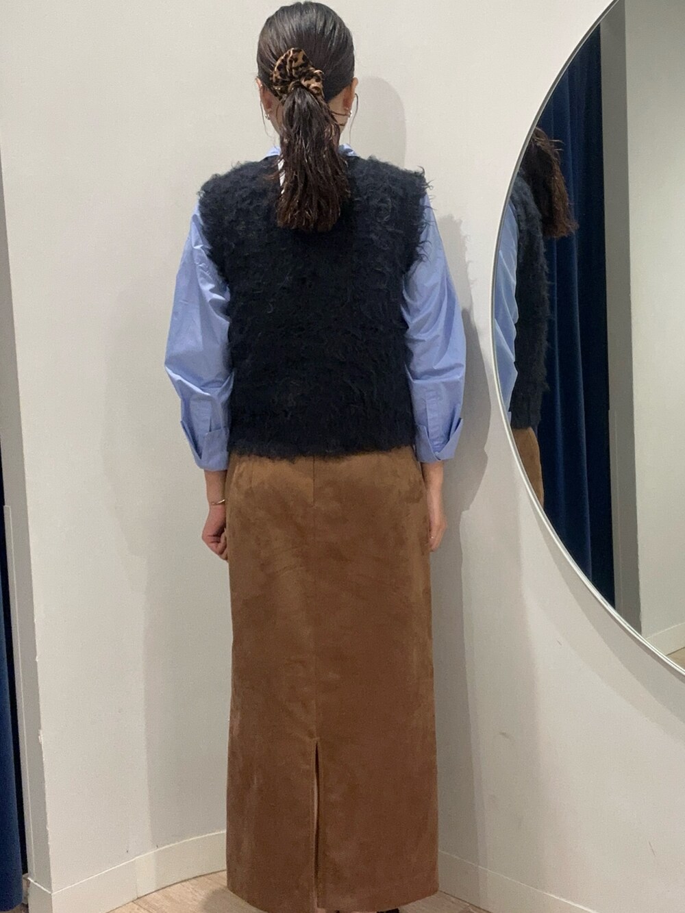 イエロー系のスカート、ブルー系のベストを着用したメンズの秋コーディネートの3枚目の写真