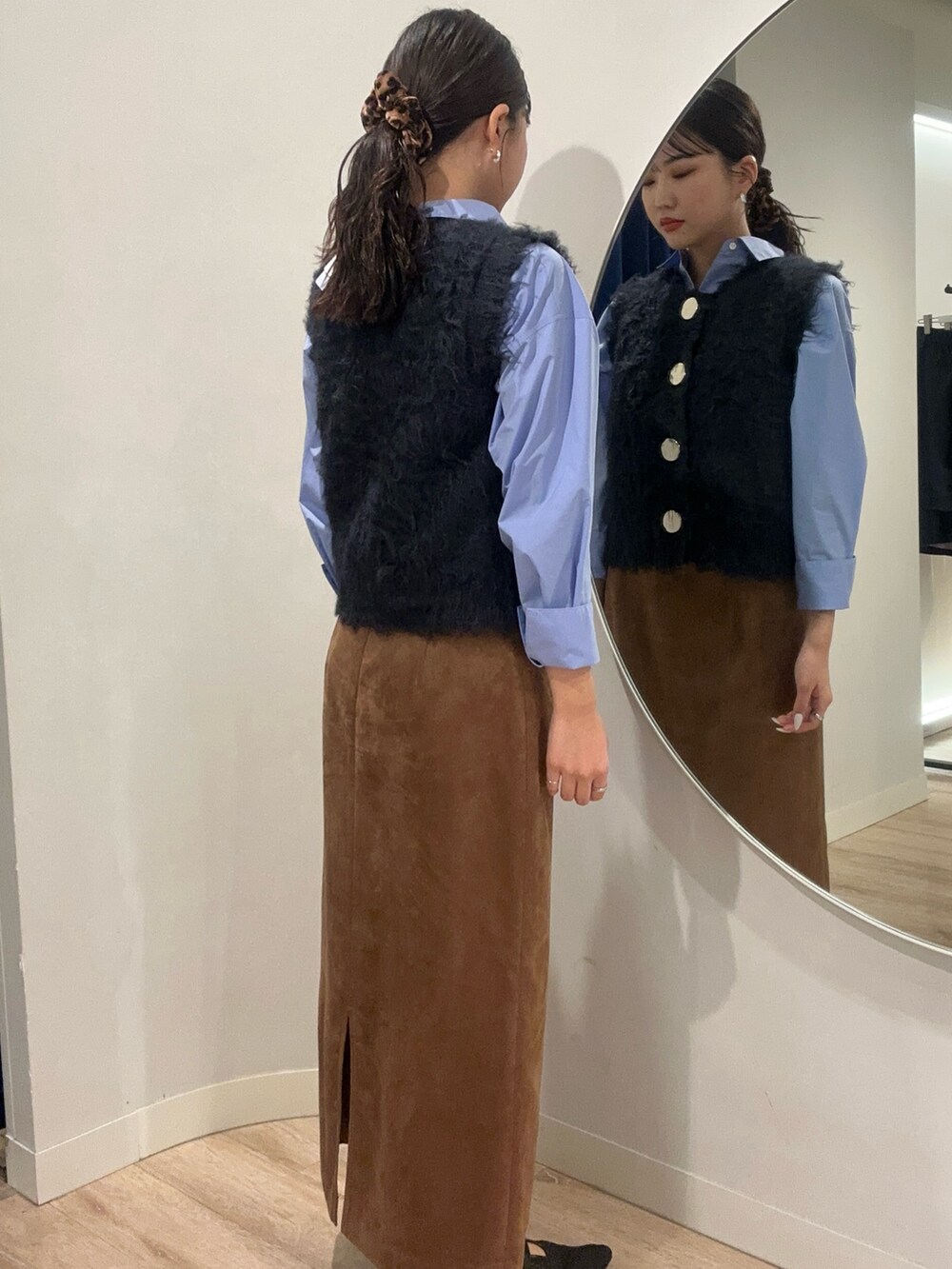 イエロー系のスカート、ブルー系のベストを着用したメンズの秋コーディネートの2枚目の写真