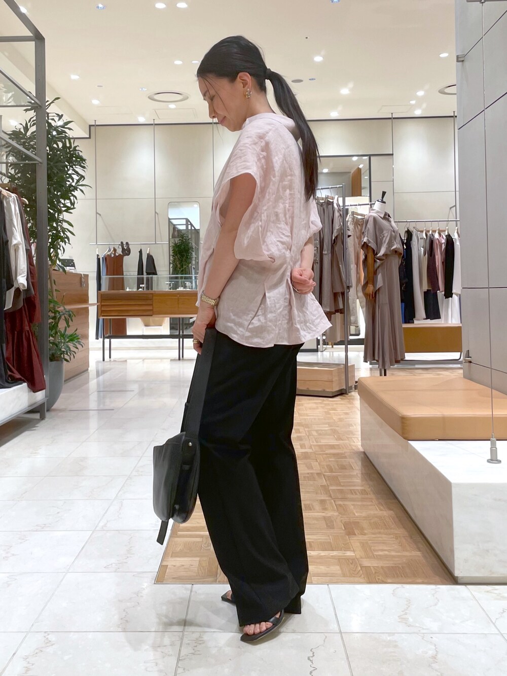 ブラック系のサンダル、ピンク系のシャツ/ブラウス、ブラック系のショルダーバッグを着用したレディースの夏コーディネートの5枚目の写真