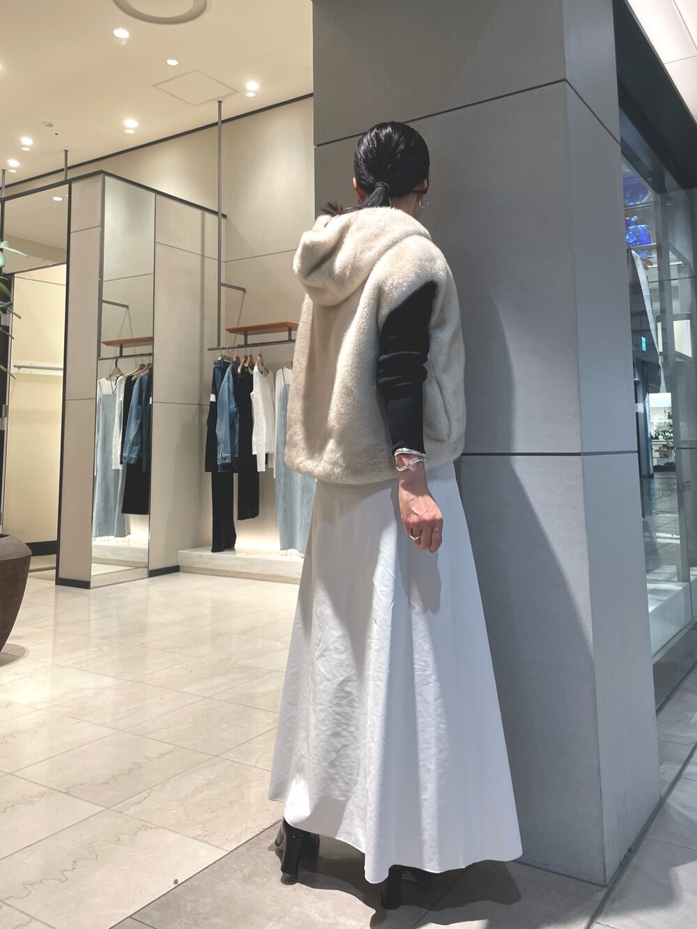 ベージュ系のスカート、ブラック系のブーツ、ブラック系のニット/セーターを着用したレディースの秋コーディネートの3枚目の写真